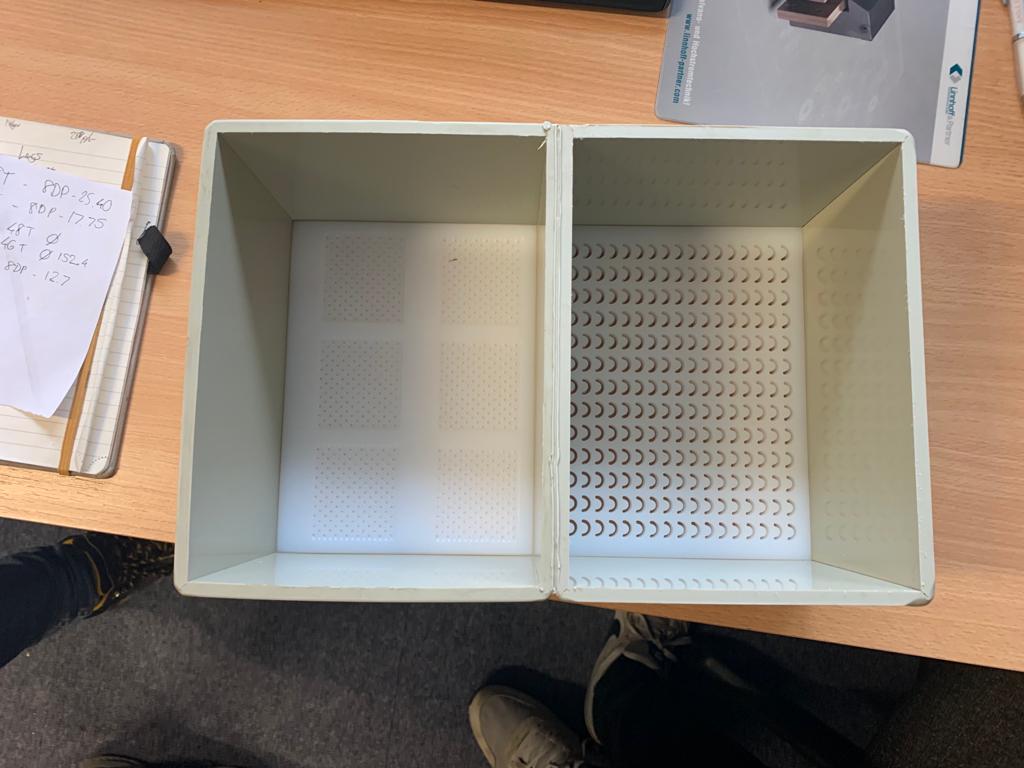 Side-by-side comparison tank showing round hole perforations vs C-Slot perforations